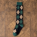 Calze al ginocchio con motivo Argyle verde scuro e nero su parquet vintage - Quadri Verdi