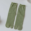 Olive green tabi socks with ribbed texture and elegant ruffle cuffs on white surface - One Size / Green