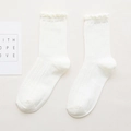 White cotton crew socks featuring delicate hollow knit texture and ruffle trim cuffs - White