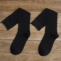 Classic black knee-high sports socks in cotton blend with ribbed cuffs on wooden background - One Size / Black