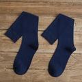Navy blue knee high socks in ribbed knit cotton blend shown on a wooden surface - One Size / Navy Blue