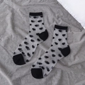 Sheer black mesh socks with heart flocked pattern and reinforced toes on gray background - Black Heart
