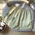 Champagne ice silk safety shorts with lace trim and bow details on a chair - One Size / Yellow