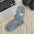 Calzino in lana blu con jacquard gattino bianco e fiocco su un tappeto beige - Fiocco a Quadri (Azzurro)