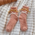 Calcetines de forro polar coral con lazos de satén sobre alfombra blanca de felpa - Talla única / Naranja
