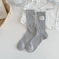 Light gray mid-calf knit socks featuring a 'HAPPY & SMILE' patch and wavy rolled edges - Gray