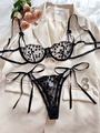 Détails d'un ensemble de lingerie en dentelle noire à cœurs avec nœuds sur une veste - S / Noir