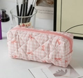 Macro detail of pink checkered quilted pencil case with orange bow pattern and zipper - Pink Gingham Bow