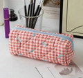Detailed view of quilted red plaid pencil case with blue bow patterns on a desk - Red Checkered Bowtie