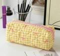 Detail of yellow checkered quilted cosmetic bag with pink bow pattern and zipper closure - Yellow Checkered Bowtie