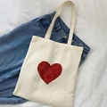 Flat lay of cream canvas tote bag with red heart print on blue denim background - Red Hand-drawn Large Heart Style(13)