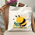 Detail of canvas tote bag featuring cartoon bee reading a book among small flowers - Reading Bee Colorful Illustration Style(12)