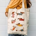 Detailed look at canvas tote bag featuring cute cartoon dachshund patterns worn by a model - Colorful Sweater Dachshund Style(3)