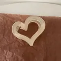 Close-up of minimalist heart-shaped hair claw clip with beige matte resin finish - Matte Hollow Heart Hair Claw
