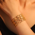 Golden hollow interlocking oval ring bracelet with textured finish on wrist - Hollow Bracelet