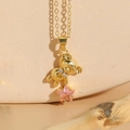 Golden bear necklace with pink star zircon and bow detail on beige ceramic stand - 14K Gold Pink Zircon (XL2439)