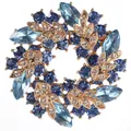 Detailed view of round garland brooch with blue crystals and gold leaf accents - Sky Blue Wreath Style