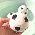 Three floating football-shaped bath toys with black and white patterns and drainage holes - Bath Soccer Ball