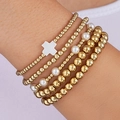 Set of 5 gold and white beaded elastic bracelets with a cross charm on a wrist - Elastic Delicate Beaded (6324201HB)