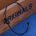 Minimalist black metal open knot bracelet with small spherical ends on a wooden box - Black