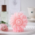 Macro detail of a blooming sunflower scented candle with intricate pink petals and ribbon - Pink
