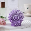 Macro detail of purple sunflower scented candle with a white mesh bow on a display tray - Purple