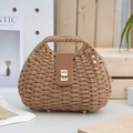Braune gewebte Strohhandtasche mit Lederklappe und goldenem Metallverschluss im Freien - Braun