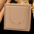 Minimalist 18k gold plated rotating smile necklace shown on a luxury jewelry box - Twisted Smile (H396) Gold