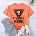 Flat lay of an orange Cowboys and Beer t-shirt with light wash jeans and white sneakers - S / Orange (Black Font)