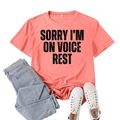 Coral pink t-shirt featuring 'SORRY I'M ON VOICE REST' print paired with blue denim jeans - S / Pink (Black Print)