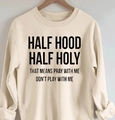 Creamy white crewneck sweatshirt with 'HALF HOOD HALF HOLY' slogan print on wooden hanger - S / Khaki (Black Font)