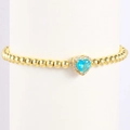 Dettaglio del ciondolo a cuore con gemma blu su bracciale a sfere dorate lucide - Marzo-Acquamarina (Stile 03)