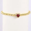 Macro view of gold beaded bracelet featuring a heart-shaped red gemstone and pavé stones - June-Alexandrite (Style 06)