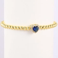 Close-up of golden beaded bracelet with a blue heart-shaped birthstone and crystals - December-Blue Zircon (Style 12)
