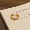 Macro shot of gold hollow-out ring with black gourd pattern on a vintage book - Style 6 Adjustable Ring