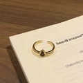 Macro detail of a gold open ring featuring a black hulu gourd charm and zircon side stones - Style 12 Adjustable Ring