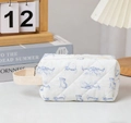 Neceser acolchado con estampado de gatos azules y asa de lona en ambiente acogedor - Gato Azul