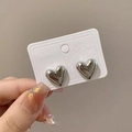 Close-up of polished silver heart stud earrings held on a white display card - Silver Pair / Silver