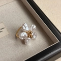 Macro d'une bague fleur en perles baroques et cœur doré sur lin beige élégant - Style de Fleur de Perle Artificielle (R84)