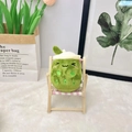 Cute avocado plush doll sitting on a mini wooden chair with cozy home background - 11cm / Dark Green (Squint)