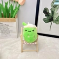 Close-up of green bubble tea plush toy with cute embroidery on a mini wooden chair - 11cm / Light Green (Squint)