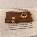 Golden flower hoop earring set with tiny zircon stones on vintage wooden display - E6964 Gold