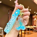 Dettaglio del portachiavi a fiore di ciliegio blu con fiori secchi e cinturino azzurro - Imballaggio in Sacchetto OPP Indipendente / Blu