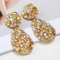 Detailed macro view of large teardrop earrings with golden alloy and multicolor crystals - Champagne