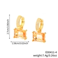 Goldene geometrische Ohrringe mit orangefarbenem Zirkon im Smaragdschliff - Champagner