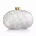 Macro detail of acrylic marble clutch bag with golden geometric clasp and pearl finish - Silver