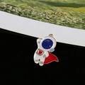 Detailed view of a cute cartoon astronaut charm with red cape and gold alloy framing - Astronaut with Red Cloak (I)