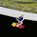 Macro detail of enamel astronaut charm riding a red comet for DIY jewelry making - Astronaut Riding Comet (II)