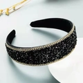 Wide fashion headband with black crystals and gold chain edges on a grey background - Black