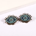 Detailed close-up of retro evil eye crystal stud earrings with gold metal eyelashes - Sky Blue